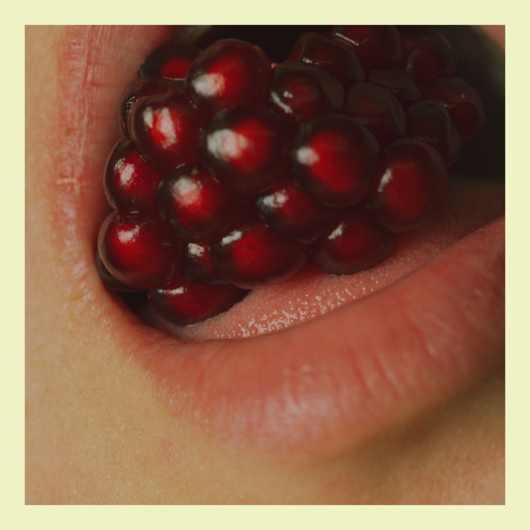 a close up of an open mouth full of pomegranate seeds 