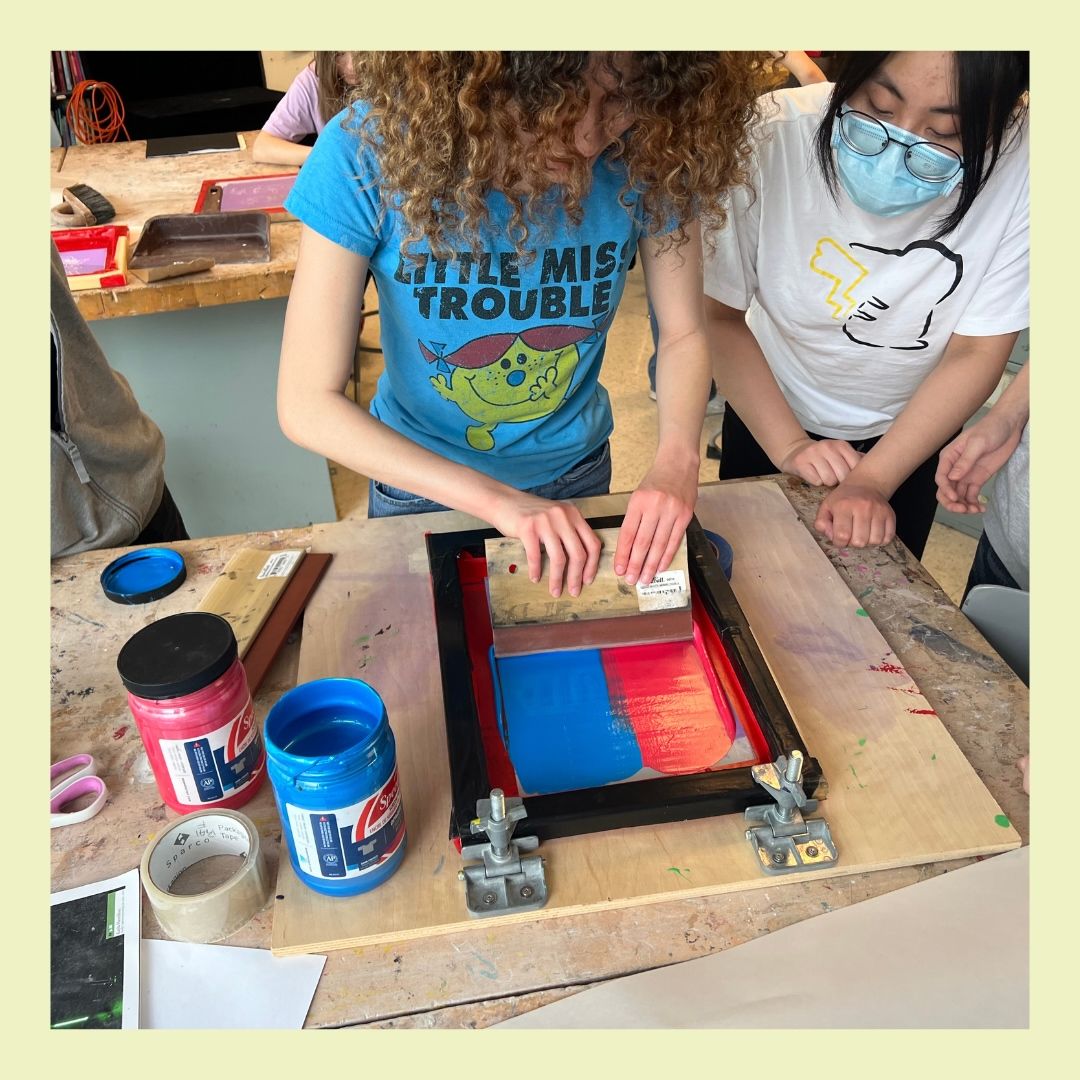 person with curly hair is instructed on using screen print