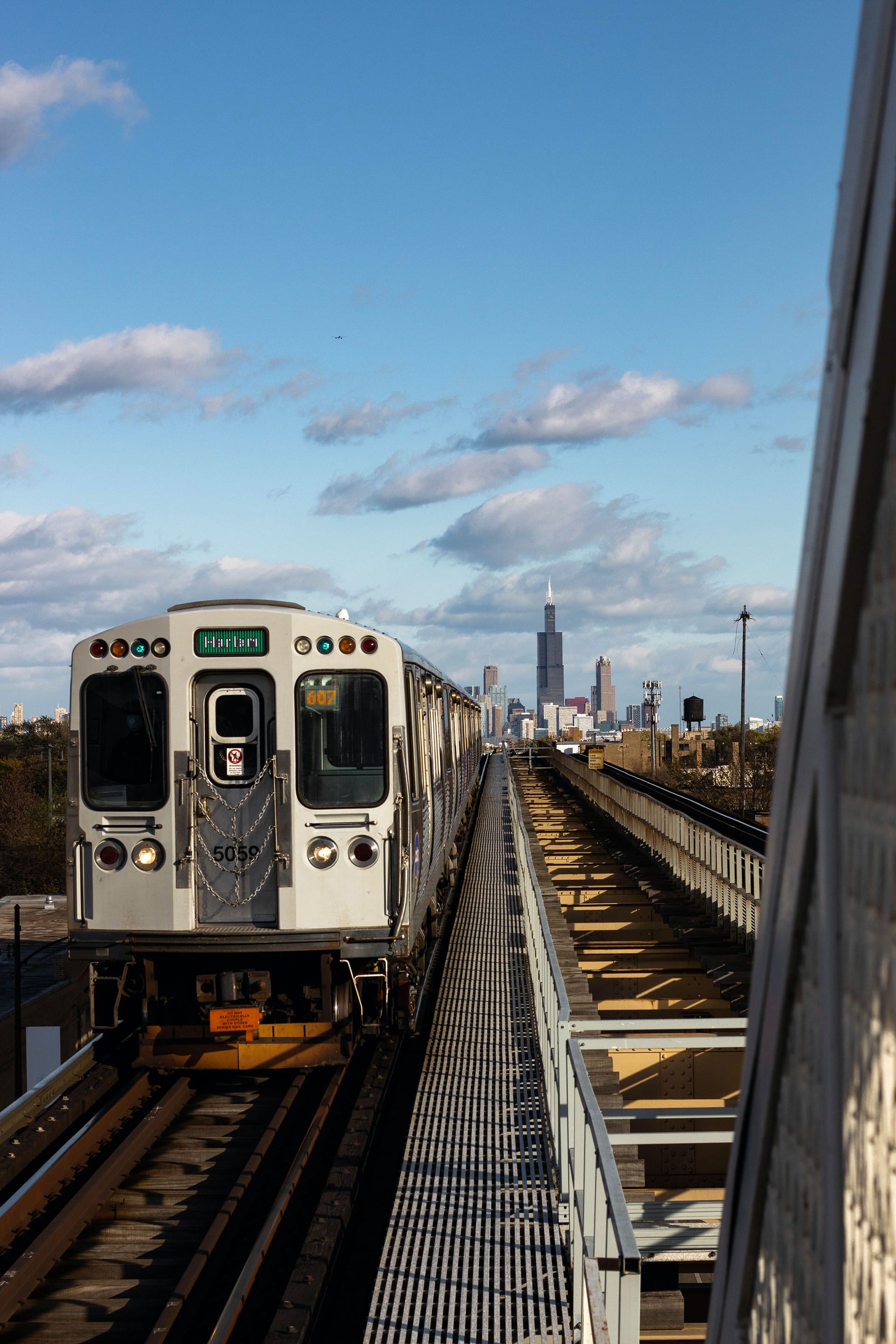 A Chicago L train headed to the Southside with the Chicago skyline behind it.